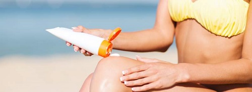 girl putting sun protection cream on beach chair
